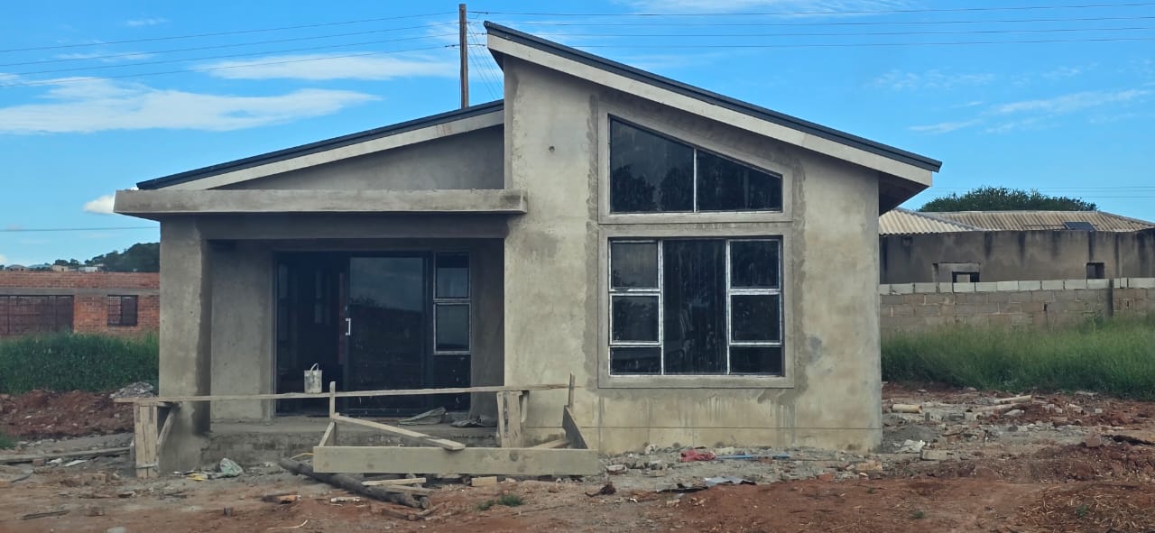 Completed single-storey house with mono-pitch roof and large feature windows